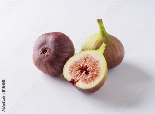 Close-up of three fig fruits with half-cut one on white floor, South Korea 