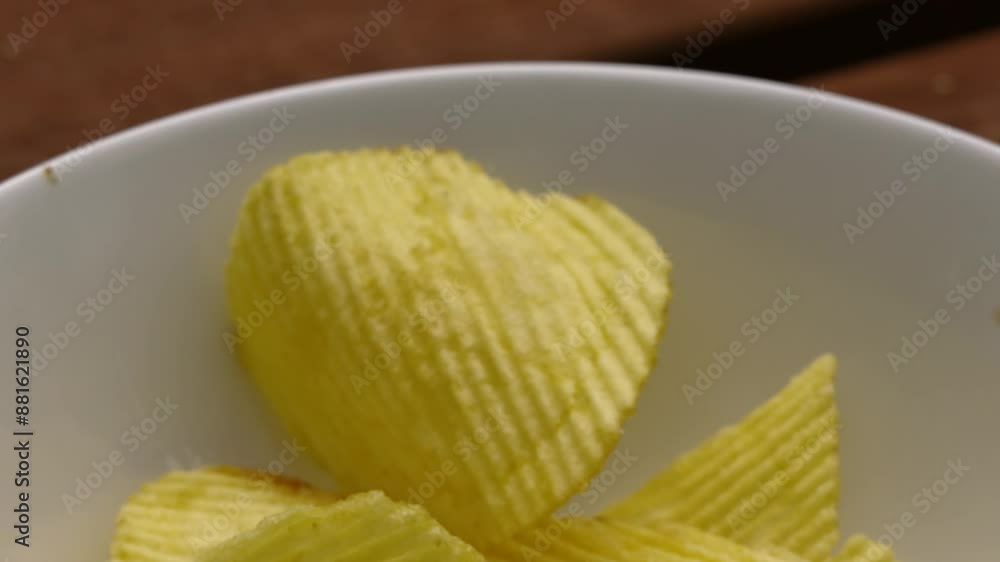 Crinkle Cut Potato Chips Crisps Falling Past Camera into White Bowl on Picnic Table in Slow Motion - 4K Food Clip Crinkle Cut Potato Chips Crisps Falling Past Camera into White Bowl on Picnic Table in Slow Motion - 4K Food Clip