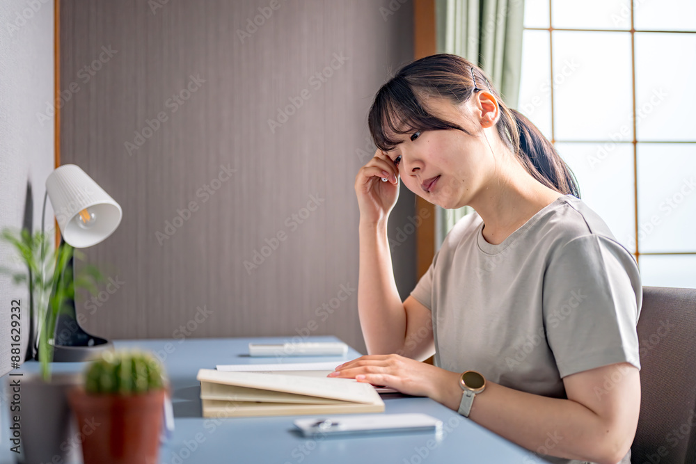 本を見て考える女性 本を見て考える女性