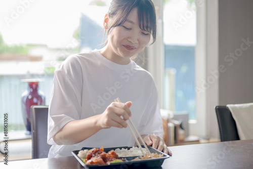 嬉しそうに弁当を食べる若い女性