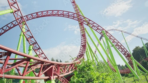Roller coaster Ride against blue sky. Roller coaster in the amusement park. Cheerful entertainments in park of attractions