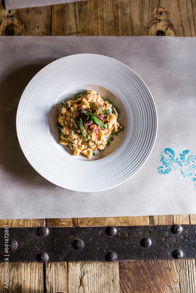 Gourmet dish of risotto with greens and garnish in a white bowl. Gourmet dish of risotto with greens and garnish in a white bowl.