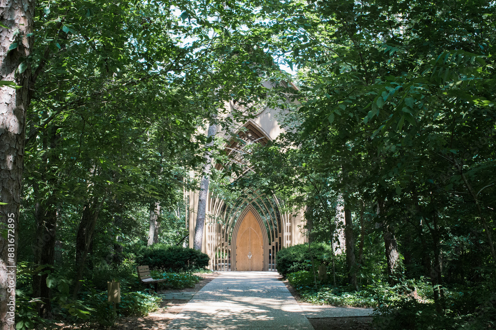 Wooden chapel entrance surrounded by lush green trees.