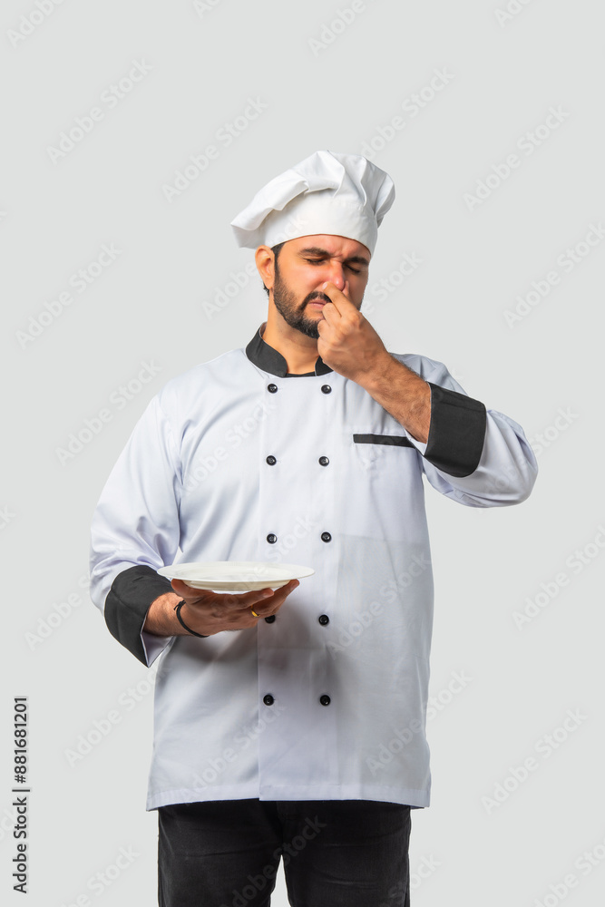 Indian asian male Chef in uniform holding rotten smelly dish, isolated white background Indian asian male Chef in uniform holding rotten smelly dish, isolated white background