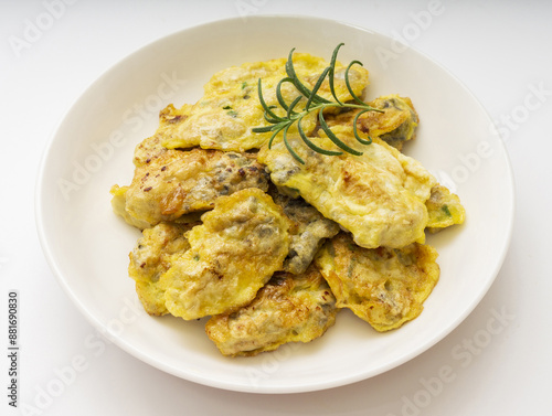 Close-up of Guljeon(oyster pancake) with herb on dish and white floor, South Korea 