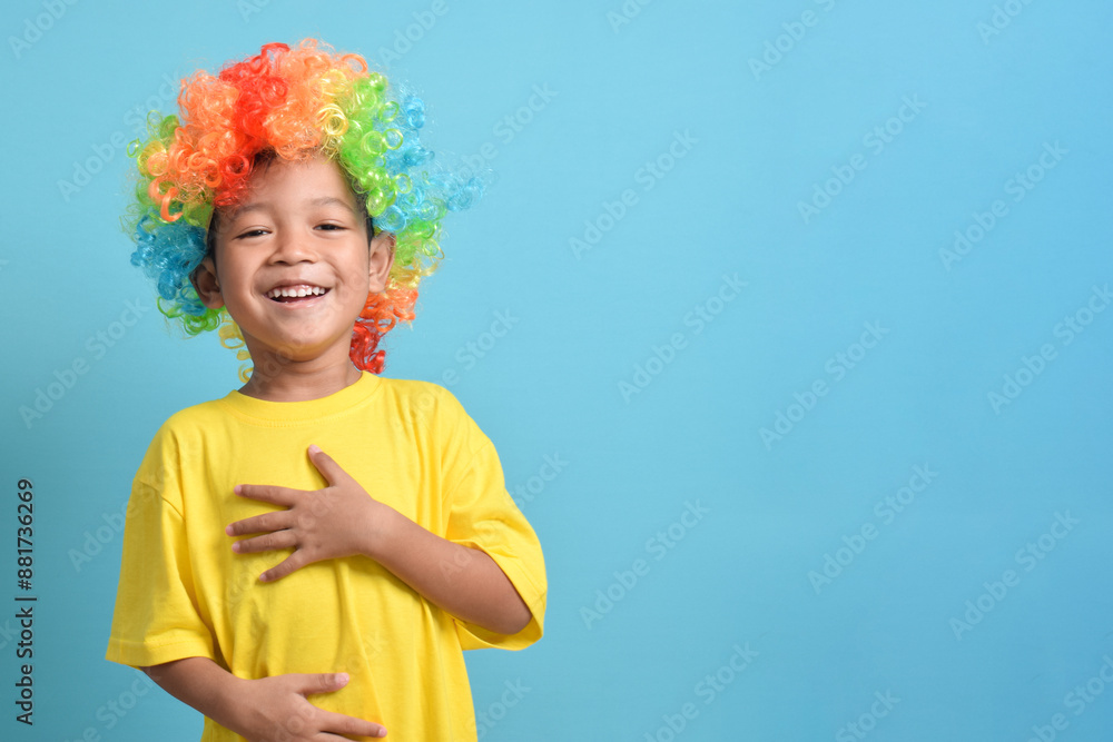 Cute little asian boy in clown wig is laughing isolated on blue background. copy space Cute little asian boy in clown wig is laughing isolated on blue background. copy space