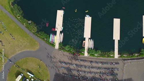 Top still shot of Triathlon at Dorney lake, triathletes running on the track and swimming towards the transition area photo