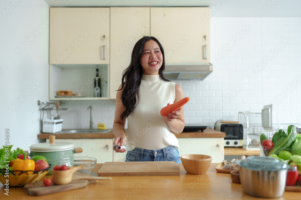 Exercise, diet, maintaining figure, fresh food that is important for losing weight and perfect health. Beautiful Asian woman peeling and chopping carrots to make a salad to eat at home. Exercise, diet, maintaining figure, fresh food that is important for losing weight and perfect health. Beautiful Asian woman peeling and chopping carrots to make a salad to eat at home.