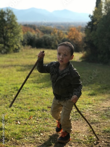 Small child trekking in the Tuscan mountains. Climbing up the mountain. Sport, outdoors activity