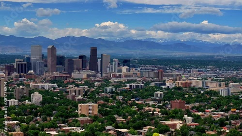 Summer in downtown Denver aerial drone pan left motion front range Colorado mountain peak foothills landscape Flat irons Red Rocks city skyscrapers neighborhood homes blue skies clouds spring photo