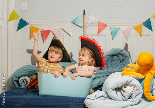 Foto Kids wearing pirate hats pretend to sail in imaginary sea