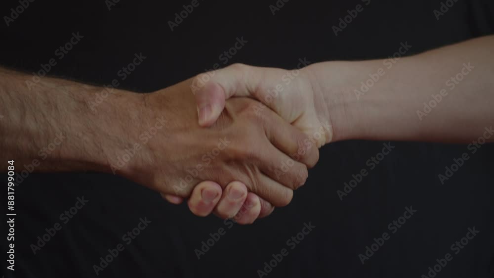 Welcome gesture. Strong male friendly handshake with bare hands on a black background Welcome gesture. Strong male friendly handshake with bare hands on a black background