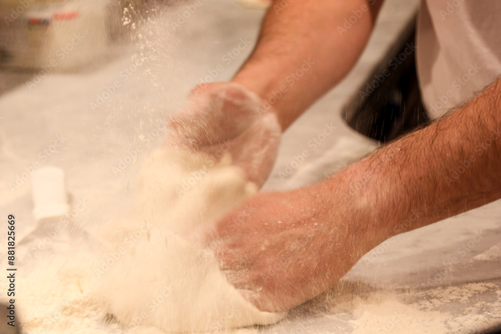 Fototapeta premium person kneading dough