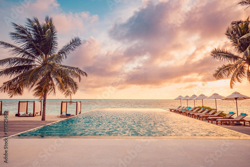 Fototapeta Naklejka Na Ścianę i Meble -  Outdoor luxury sunset over infinity pool swimming summer beachfront hotel resort, tropical landscape. Beautiful tranquil beach holiday vacation background. Amazing island sunset beach view, palm trees