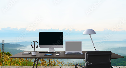 Working table with computer, tablet , book, outdoor in the morning in front of mountain view background