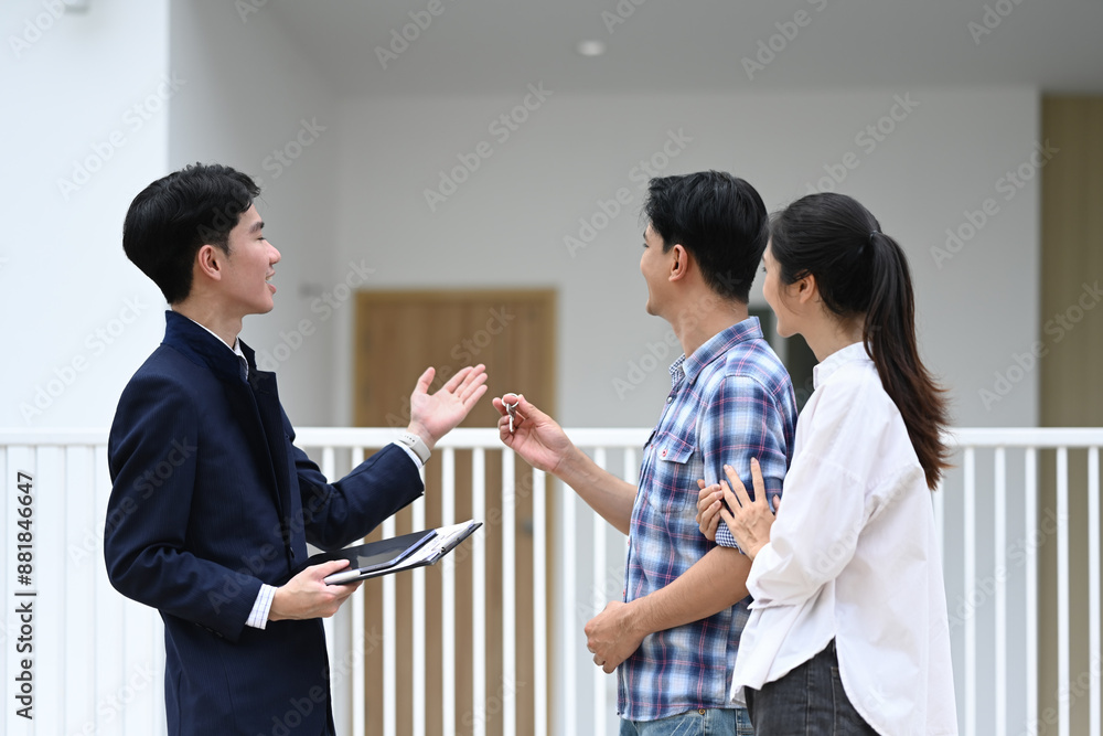 Real estate agent showing a house for sale to couple buyers. Real estate and property purchase concept Real estate agent showing a house for sale to couple buyers. Real estate and property purchase concept