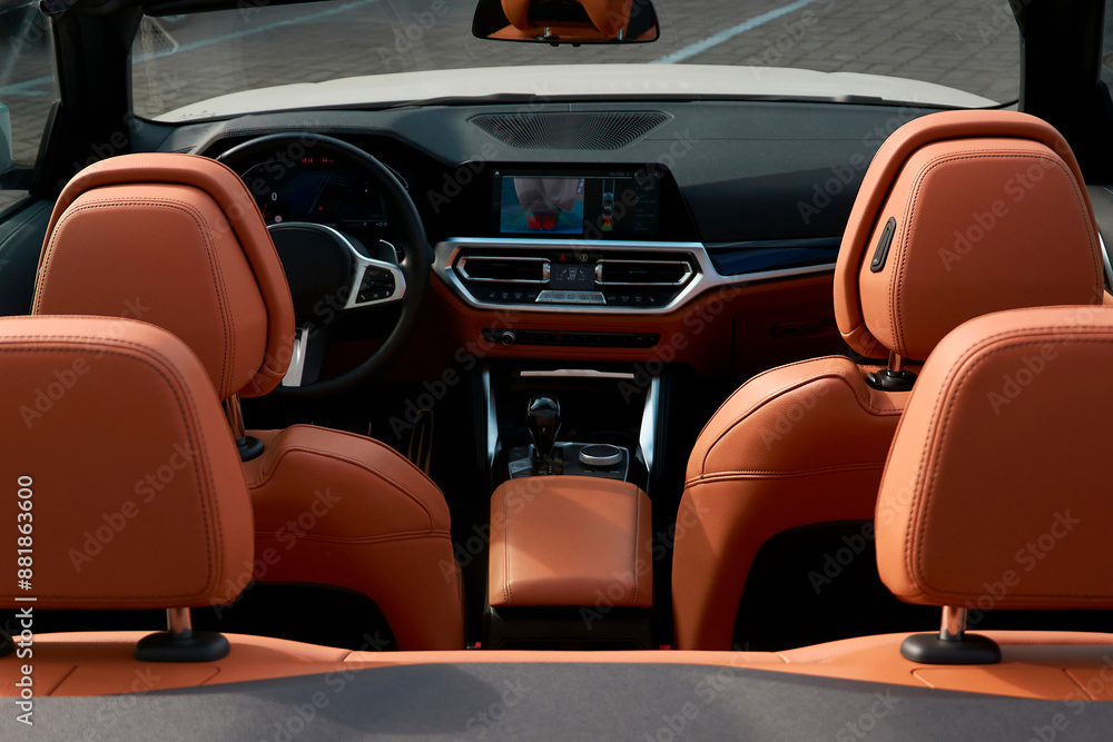 Fototapeta premium View of the interior of the convertible from the trunk side. You can see the brown backs of the seats and the dashboard.