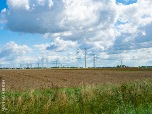Groningen, Netherlands - August 9th 2023: Huge high-voltage transmission line over farmland
