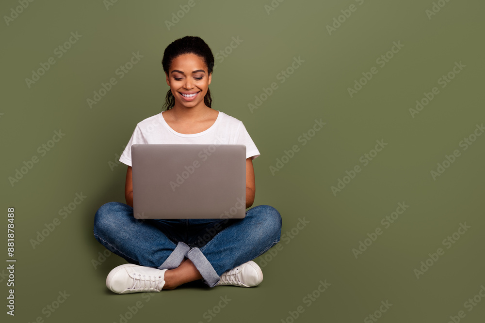 Photo portrait of cheerful young girl working sitting floor with laptop studying courses online isolated on khaki color background Photo portrait of cheerful young girl working sitting floor with laptop studying courses online isolated on khaki color background