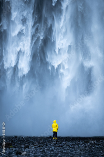 Obraz na płótnie Stunning view of the Skógafoss Waterfall with a tourist wearing a yellow jacket. Skógafoss is one of the biggest waterfalls in Iceland, situated on the Skoga River in the south of Iceland. w salonie