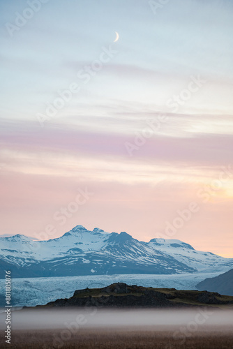 Obraz na płótnie Stunning view of a dramatic landscape with some snowy mountains and a glacier in the distance during a beautiful sunrise, Iceland. w salonie