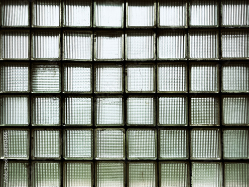 A window made of green glass blocks in a dark room