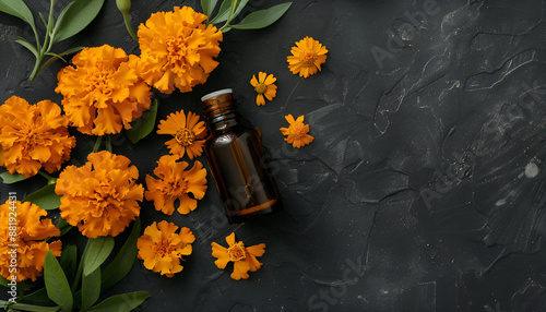 Aromatherapy essential oil with marigold flowers on black background with copy space for your text. Top view photo