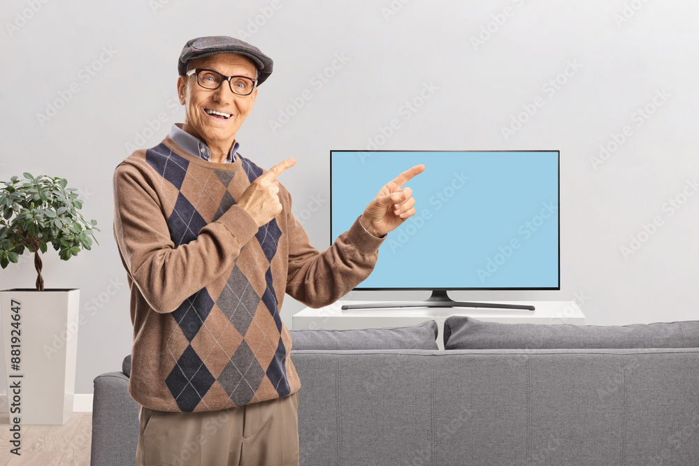 Elderly man with glasses smiling and pointing at a tv screen Elderly man with glasses smiling and pointing at a tv screen