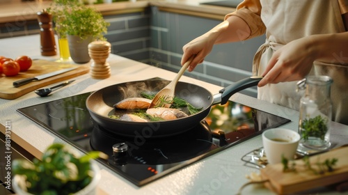 Cooking healthy meal in modern kitchen. Home chef frying fish fillets in non-stick pan. Fresh ingredients and herbs on counter. Home-cooked dish in preparation. Culinary creativity in action. AI