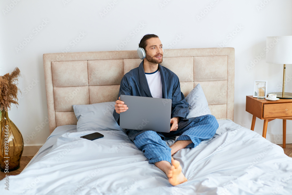 A man using a laptop on a bed. A man using a laptop on a bed.