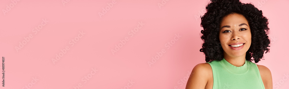 A woman with curly hair stands confidently against a vibrant pink background. A woman with curly hair stands confidently against a vibrant pink background.