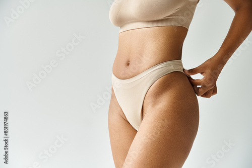 Fotografija A woman in cozy tan bikini top and panties poses gracefully.