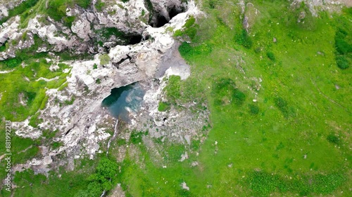 On the shores of Lake Mont Cenis between France and Italy, 4K drone video between the lake and the rock, vertical view, misty atmosphere