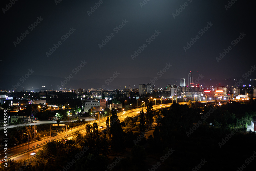 Fototapeta premium Night view of the city of Sofia with glowing lights of the cars speeding on a highway