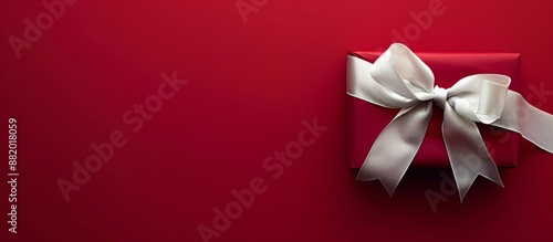 Single Red Gift Box With White Ribbon Bow on Red Background