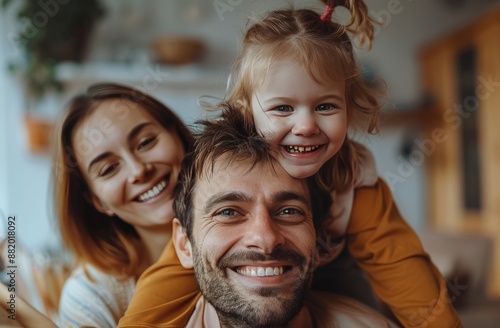 Happy Family Portrait With Smiling Couple and Daughter Indoors