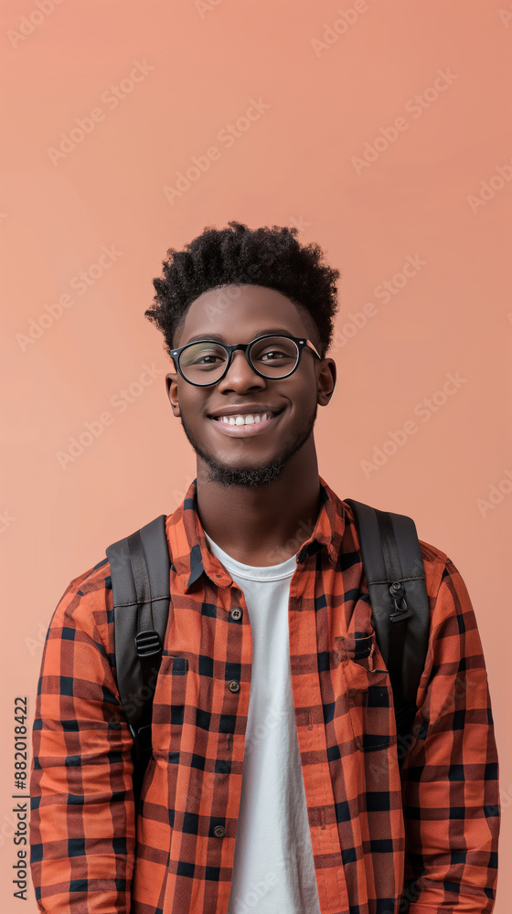 A young man with glasses and a plaid shirt is smiling for the camera A young man with glasses and a plaid shirt is smiling for the camera