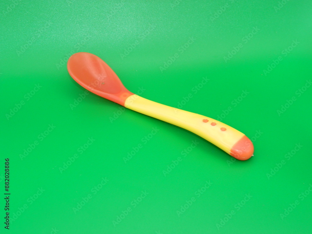 Macro photo of children's educational eating equipment on a green background.
