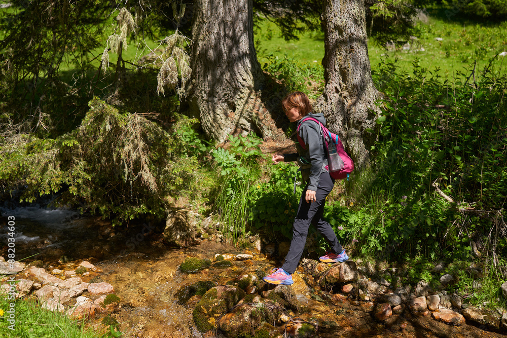 Woman hiker on a trail in the mountains Woman hiker on a trail in the mountains