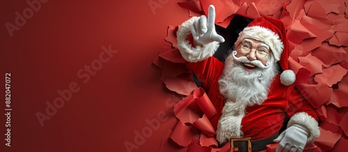 Joyful Santa Claus Breaking Through Red Paper Background