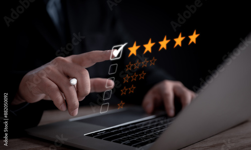 Obraz na płótnie business using a laptop gives 5-star rating to highlight exceptional service