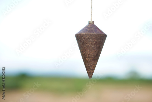 Foto Old plumb bob, plummet or conical iron hanging with rope for measurement level, use for determining perpendicularity