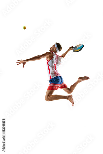 Obraz na płótnie Concentrate man, beach tennis player in colorful sportswear hitting ball with racket in a jump isolated on white background. Concept of sport, active and healthy lifestyle, hobby, games, competition w salonie