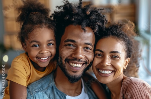 Happy Family Portrait With Smiling Couple and Daughter Indoors