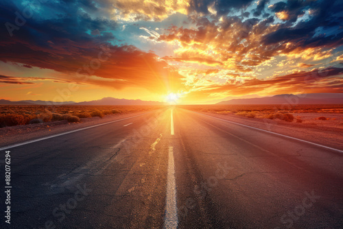 A lonely road stretching through a desert at sunset