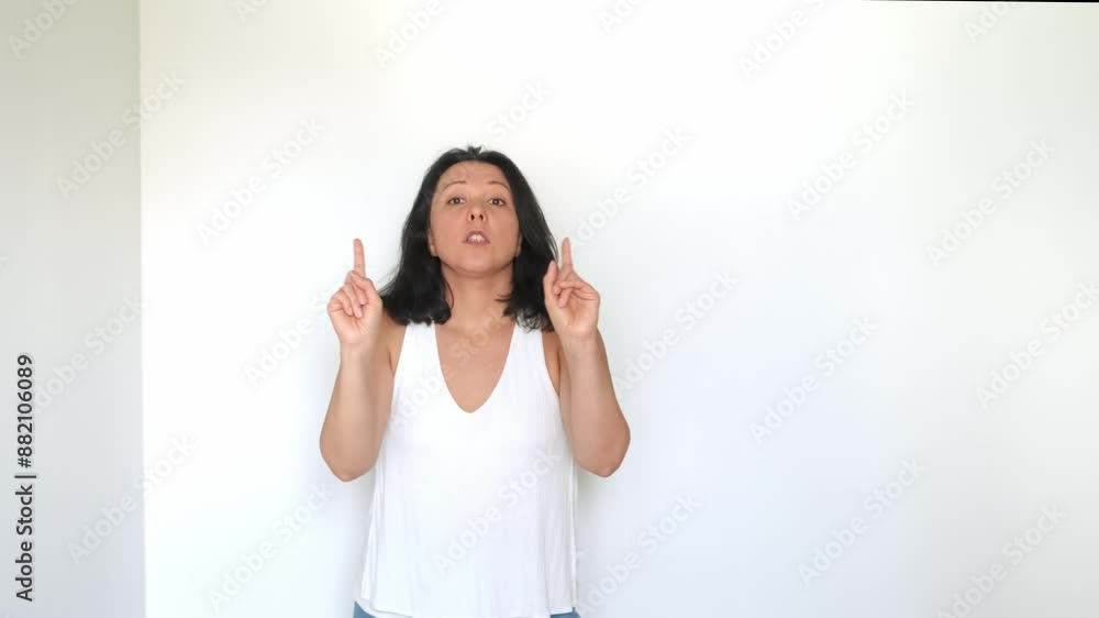 A woman in a white top expresses disapproval with raised hands and a firm no, set against a plain background. This video highlights authentic human reactions and is perfect for content focusing on A woman in a white top expresses disapproval with raised hands and a firm no, set against a plain background. This video highlights authentic human reactions and is perfect for content focusing on