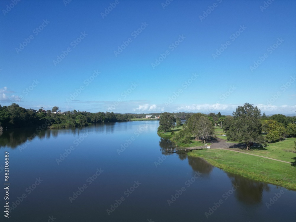 Serene river landscape with lush greenery and a clear blue sky Serene river landscape with lush greenery and a clear blue sky
