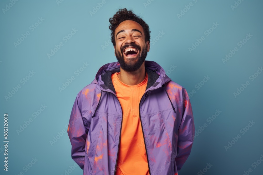 Portrait of a happy man in his 30s wearing a functional windbreaker isolated in blank studio backdrop Portrait of a happy man in his 30s wearing a functional windbreaker isolated in blank studio backdrop