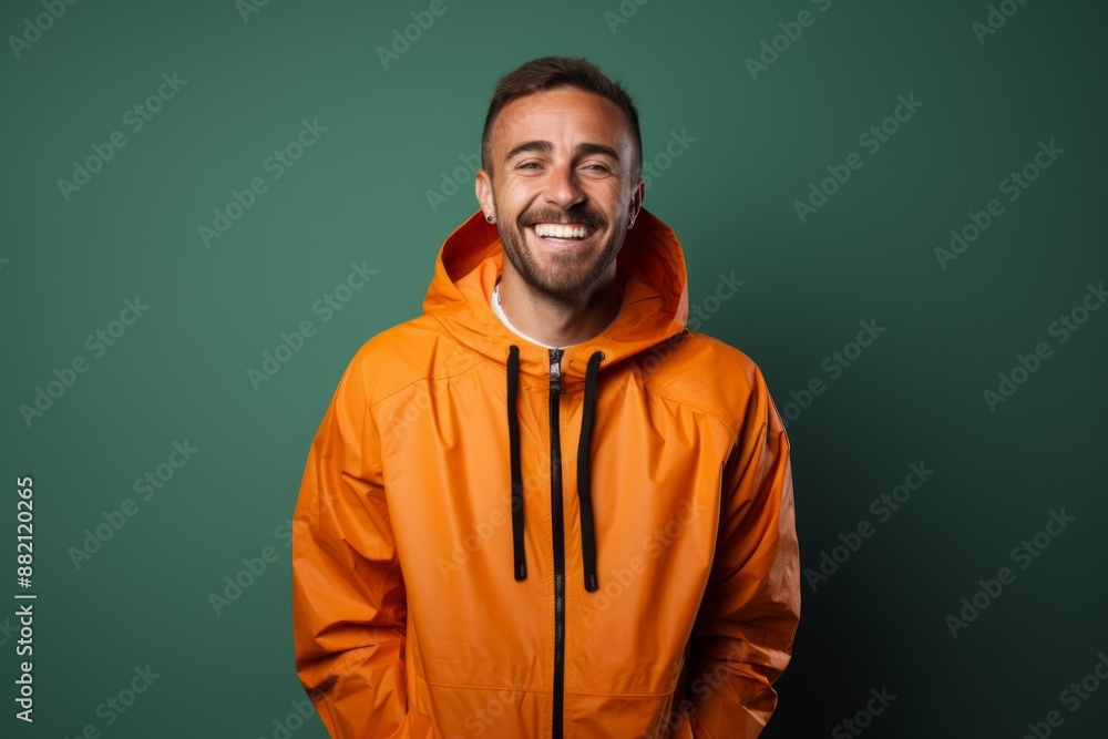Portrait of a happy man in his 30s wearing a functional windbreaker in front of blank studio backdrop Portrait of a happy man in his 30s wearing a functional windbreaker in front of blank studio backdrop