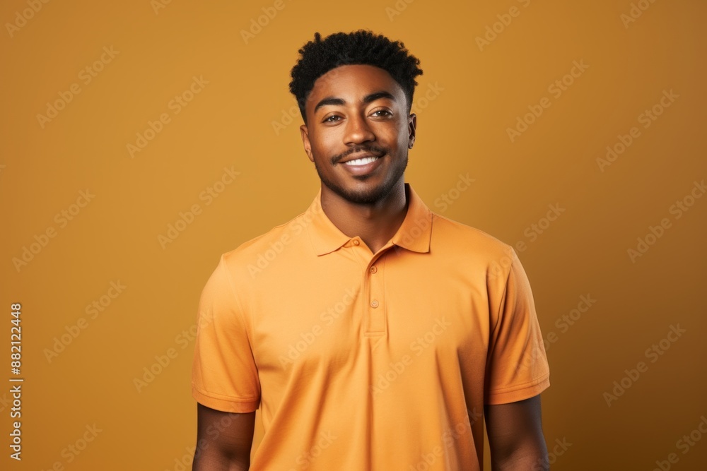 Portrait of a happy afro-american man in his 20s donning a classy polo shirt over blank studio backdrop Portrait of a happy afro-american man in his 20s donning a classy polo shirt over blank studio backdrop